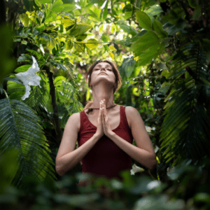 woman forest bathing in prayer hands looking up